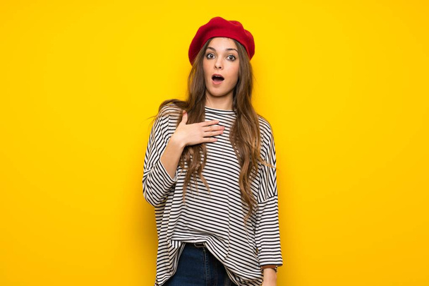 Girl with french style over yellow wall surprised and shocked while looking right - Foto, afbeelding
