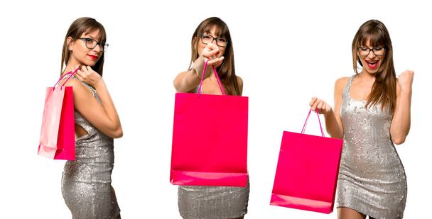 Set of Woman wearing a sequined dress with champagne celebrating new year 2019 surprised while holding a lot of shopping bags on isolated background - Photo, Image