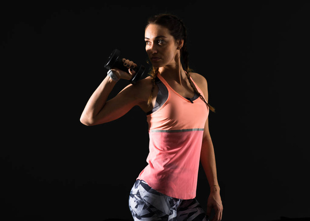 Sport woman on dark background making weightlifting - Photo, Image