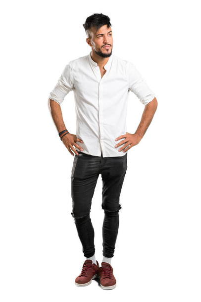 A full-length shot of a Arabic young man with white shirt having doubts and with confuse face expression on isolated white background - Photo, image