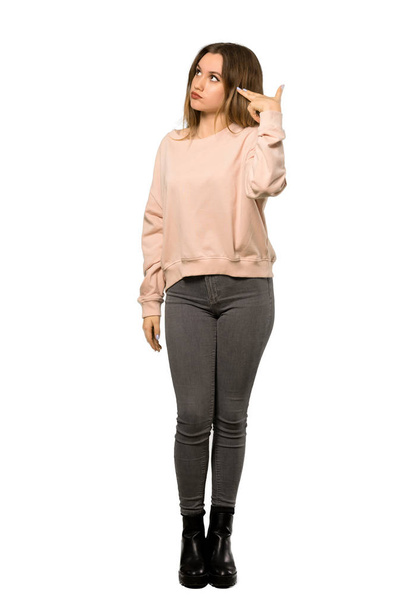 A full-length shot of a Teenager girl with pink sweater with problems making suicide gesture over isolated white background - Foto, afbeelding