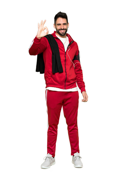 Full-length shot of Handsome sportman showing an ok sign with fingers on isolated white background - Photo, Image