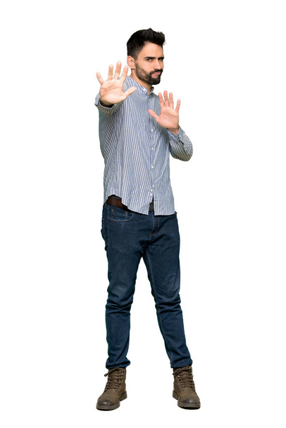 Täyspitkä laukaus tyylikäs mies paita on hieman hermostunut ja peloissaan venyttely kädet eteen eristetty valkoinen tausta
 - Valokuva, kuva