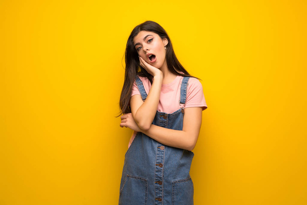 Teenager girl over yellow wall surprised and shocked while looking right - Photo, Image