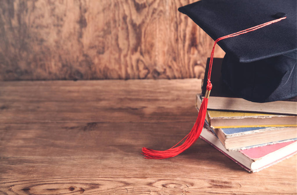 Graduation hat with books on table. Education concept - Photo, Image