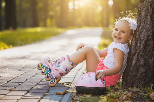 smiling Little girl on roller skates at summer park - Zdjęcie, obraz