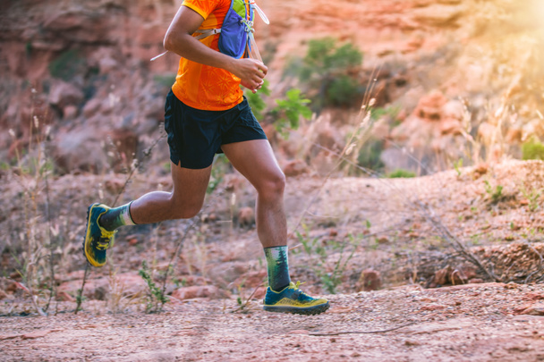 A man Runner of Trail . and athlete's feet wearing sports shoes for trail running in the mountains - Photo, Image