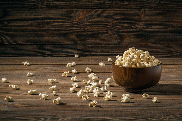 Popcorn dans un bol sur de vieilles planches en bois. Espace de copie
. - Photo, image