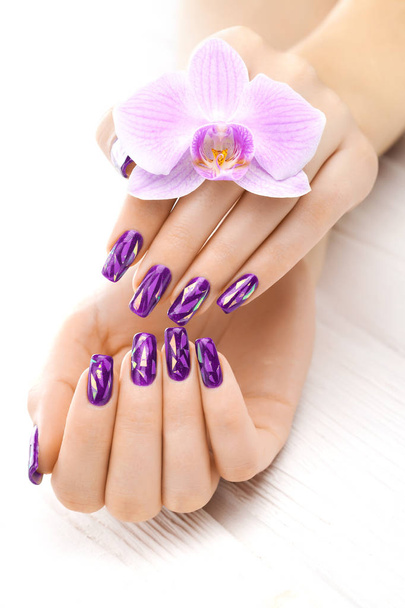 beautiful violet manicure with decor, orchid, towel and candle on the white wooden table. spa - Fotoğraf, Görsel