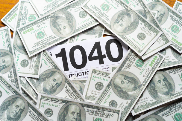 Yhdysvaltain verolomake 1040 Yhdysvaltain dollarin setelillä. - Valokuva, kuva