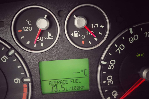 Primo piano a colori del display digitale di un'auto, che mostra un consumo di carburante molto elevato
. - Foto, immagini