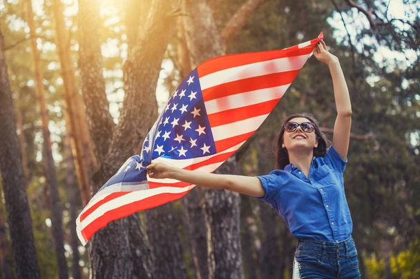 happy smiling young woman with national american flag outdoors. Independence Day, 4th July - Foto, Bild