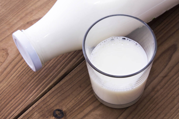 glass and bottle of milk on wooden table - Fotografie, Obrázek