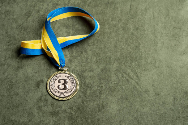 die Bronzemedaille für den dritten Platz mit gelb-blauer Schleife, Kopierraum - Foto, Bild