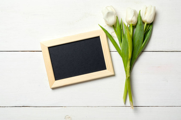 Blank card for invitation or congratulation with bunch of white tulips flowers on white wooden table. Vintage banner mockup for spring holidays, International Womans Day, 8 march, Wedding, Mothers Day - Фото, изображение
