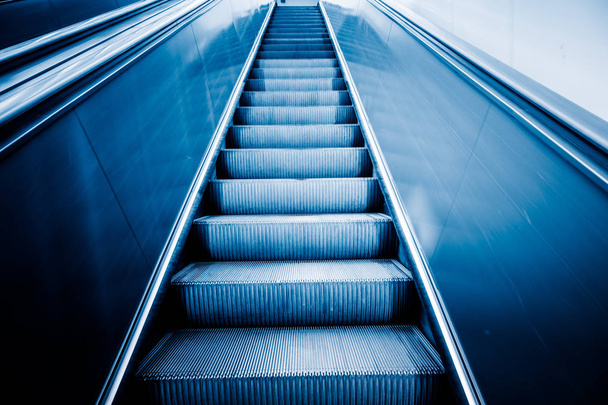 Rolltreppe eines modernen Bürogebäudes, blau getönte Bilder. - Foto, Bild