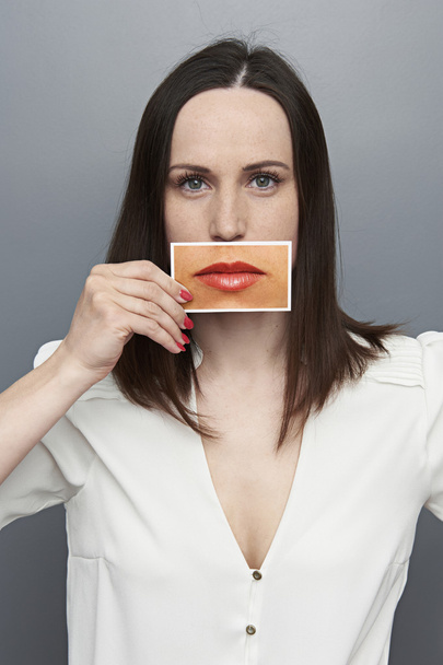 Frau hält Bild mit großen Lippen - Foto, Bild