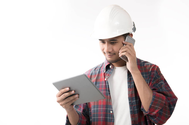 Porträt eines asiatischen Ingenieurs mit Smartphone und Tablet isoliert auf weißem Hintergrund - Foto, Bild