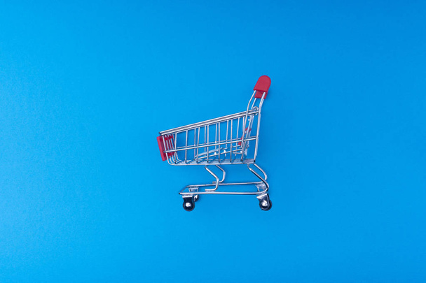 Ostoskori sinisellä pohjalla, liike- ja ostoskonsepti. Valikoiva painopiste
 - Valokuva, kuva