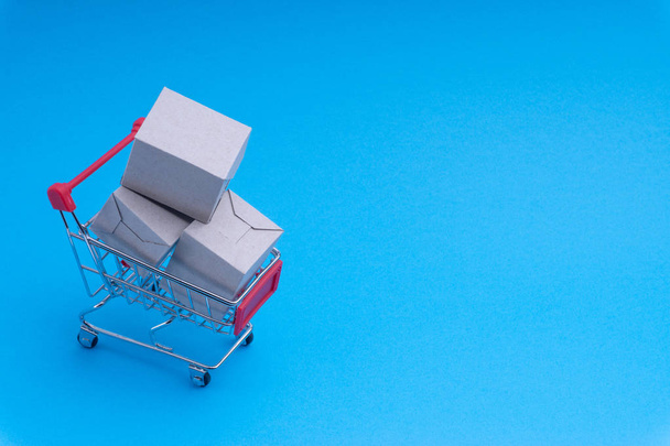 Nákupní košík a box na modrém pozadí, obchodní a nákupní koncept. Selektivní fokus - Fotografie, Obrázek