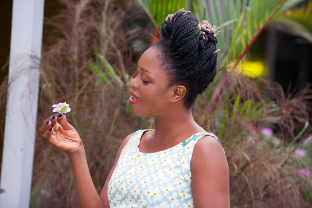 jonge gelukkig zakenvrouw staan op straat en een witte bloem in de hand houden - Foto, afbeelding