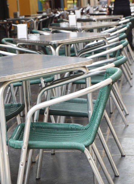 Aberto café de rua vazio, mesas e cadeiras com estrutura metálica e móveis de vime, foco seletivo e close-up - Foto, Imagem