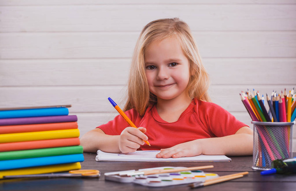 Back to school. Cute child is sitting at a desk indoors. Kid is learning in class on the white background - Foto, immagini