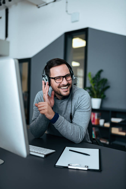 Happy businessman working with headset at modern office. - Φωτογραφία, εικόνα