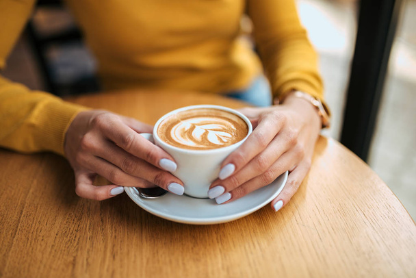 Drinking cup of latte art coffee. - Foto, afbeelding