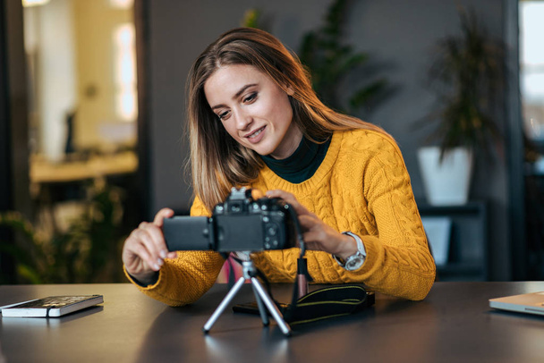 Young woman preparing camera for vlogging. - Фото, зображення