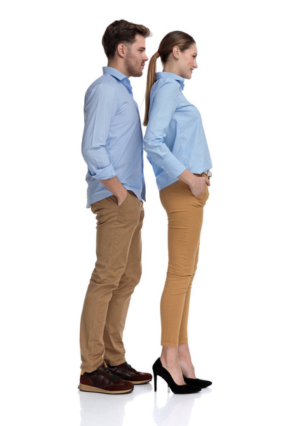 joven pareja casual con las manos en los bolsillos, espera en la fila, imagen de cuerpo completo sobre fondo blanco
 - Foto, imagen