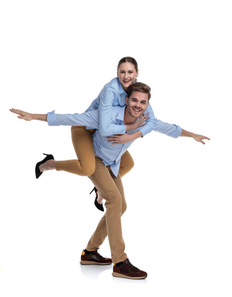 being in love makes all of us fly!  man doing the air plane while carrying woman on his back - Photo, image
