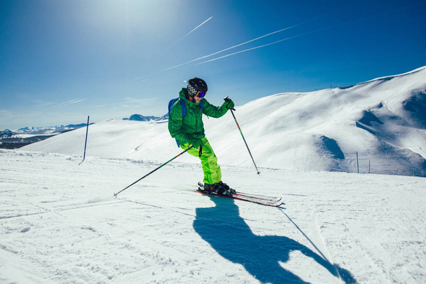 Genç sporcu serbest stil kayakçı kış mevsiminde güneşli bir günde tepeden aşağıya doğru koşarken eğleniyor. - Fotoğraf, Görsel