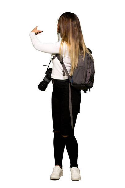 Hoofdgedeelte van jonge fotograaf woman wijzend terug met de wijsvinger - Foto, afbeelding