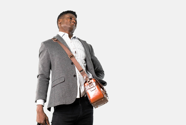 Αφρικανική αμερικανική επιχείρηση άνθρωπος ταξιδεύει με βαλίτσες με πόνο στην πλάτη σε απομονωμένες γκρι φόντο - Φωτογραφία, εικόνα