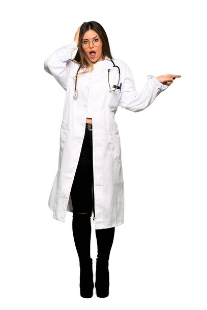 Pełne ciało kobiety młody lekarz, wskazując palcem na bok i prezentacji produktu - Zdjęcie, obraz