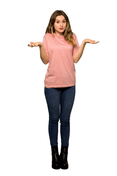 ピンクのセーターは分離の白い背景の上の胸に手を置いている間、すごく笑顔で 10 代の女の子のフルレングス ショット - 写真・画像