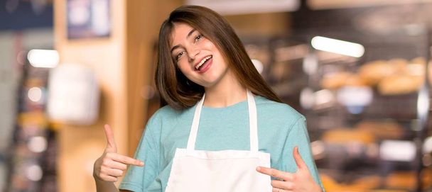 Tyttö esiliina ylpeä ja omahyväinen rakastunut itse käsite leipomossa
 - Valokuva, kuva