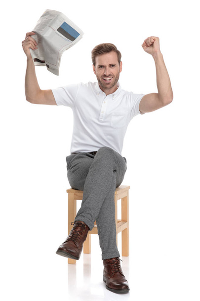 casual seated man celebrates good news with hands in the air  on white background - Photo, Image
