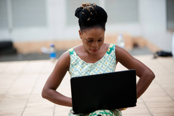 Close up of woman working on laptop sitting outdoors - Photo, Image