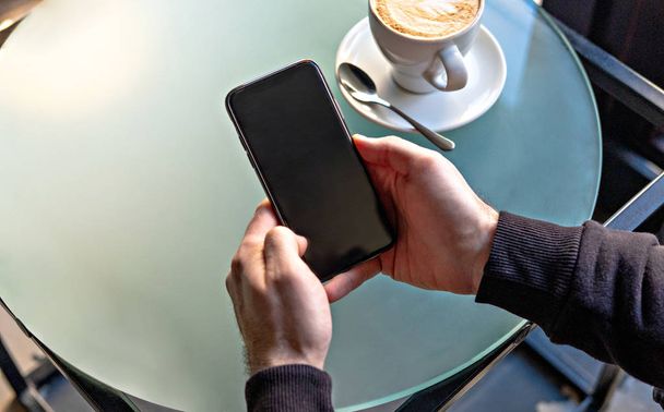 Близкий обзор бизнесмена, использующего смартфон в кафе
 - Фото, изображение
