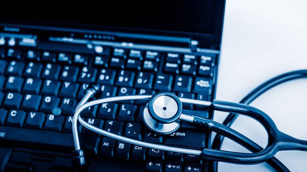 Laptop mavi tonlu görüntülerde elektronik tıbbi, stetoskop. - Fotoğraf, Görsel