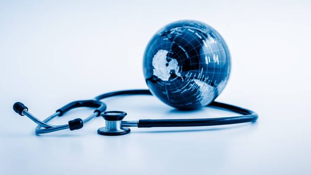 Wereldwijde gezondheidszorg. Globe en stethoscoop, studio shot.blue getinte beelden. - Foto, afbeelding
