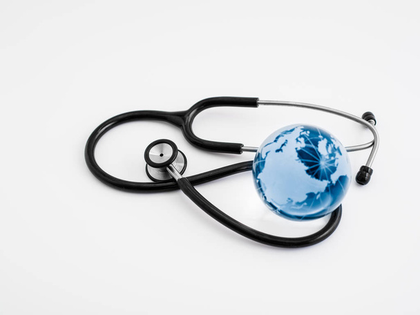Global healthcare. Globe and stethoscope, studio shot. - Photo, Image