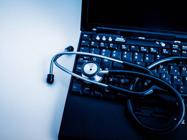 Elektroniczny stetoskop medycznych, na laptopie niebieski stonowanych obrazów. - Zdjęcie, obraz