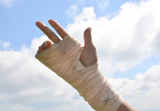 people with wrist pain in an Elastic Bandage exercise fingers with sky background - Photo, Image