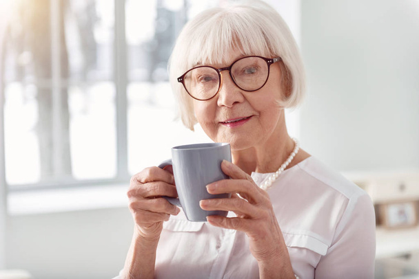 Close up of pretty elderly woman drinking coffee - Foto, afbeelding