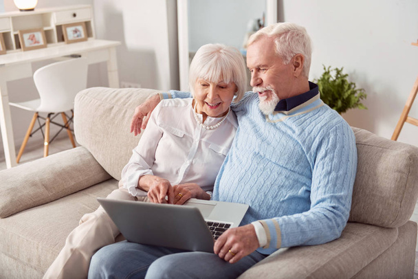 Pleasant elderly couple choosing new laptop in online store - Fotografie, Obrázek