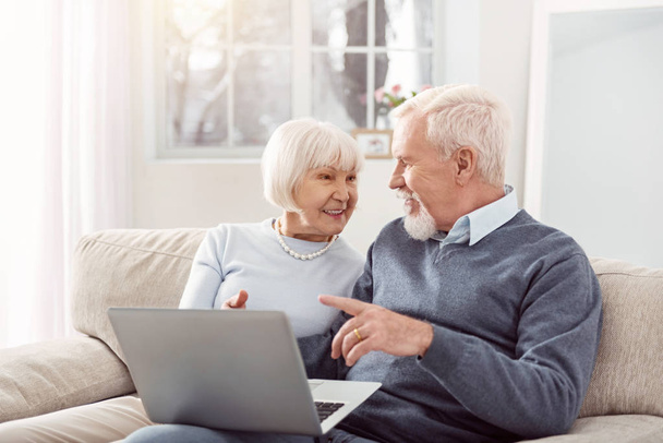 Happy elderly couple discussing online article together - Valokuva, kuva