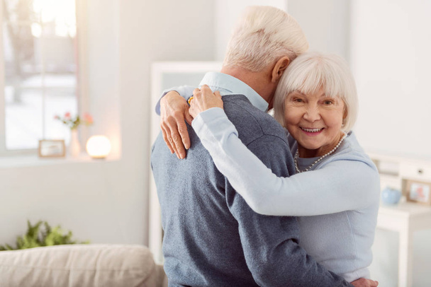Cheerful elderly woman posing while hugging her husband - Fotoğraf, Görsel